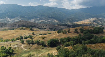 Naklejka premium Sunny midday landscape photo of a beautiful meadows and big mountains in the background.