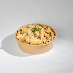 Pasta with mushrooms and red sauce on a white background