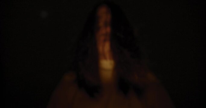 Horror scene of a mysterious Scary Asian ghost woman creepy face with hair covering the face looking to camera with background dark scene movie at night, holiday Halloween concept
