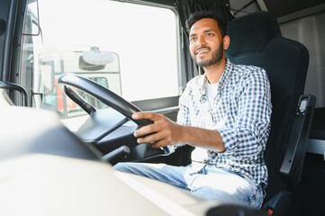 Happy professional truck driver driving his truck. Copy space.