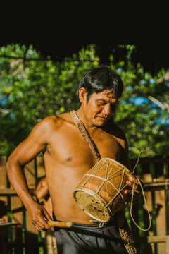 Local man playing drum in sunlight