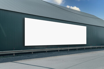Long white blank commercial banner mounted on building wall on highway roadside
