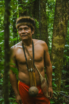 Shirtless man of Amazon tribe with tools on neck
