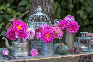 florales Garten-Arrangement mit Dahlien-Blumensträußen in Pink in vintage Gefäßen