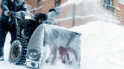 the janitor removes snow with a snow plow