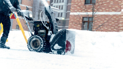 the janitor removes snow with a snow plow