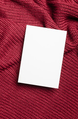 Blank greeting card mockup on knitted background