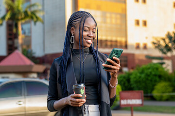 young African woman with braids looking at her cell phone