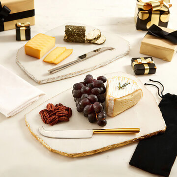 Cheese, grape, almonds and gift boxes on the table. Holiday celebration concept