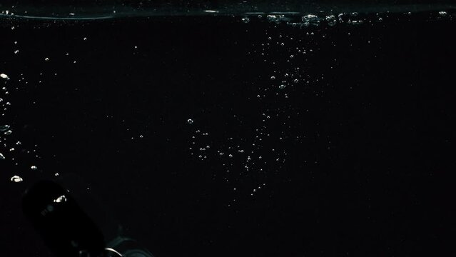 Mobile Cell Phone sinking into water with black background concept of risk and default