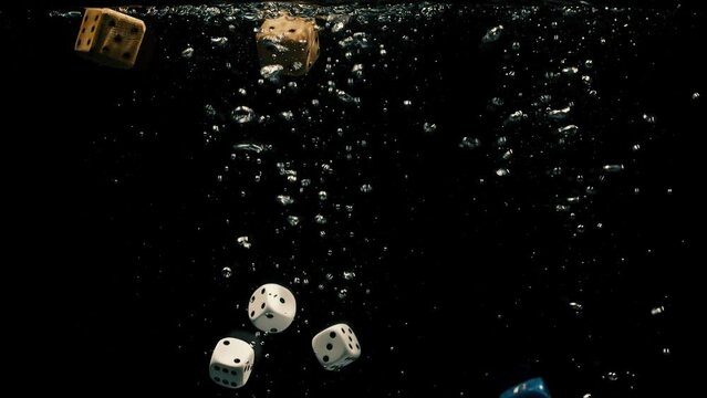 Group of colorful dice dropping on the water with black background