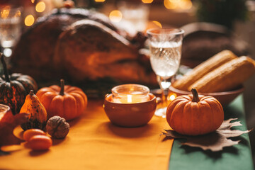 Thanksgiving holiday dinner table setting with fall decoration and pumpkins