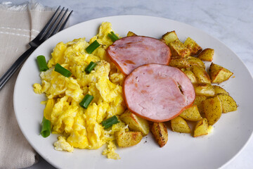 canadian bacon on scramble egg with home fries