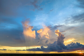 White fluffy cumulonimbus clouds forming before thunderstorm on evening sky. Changing stormy...