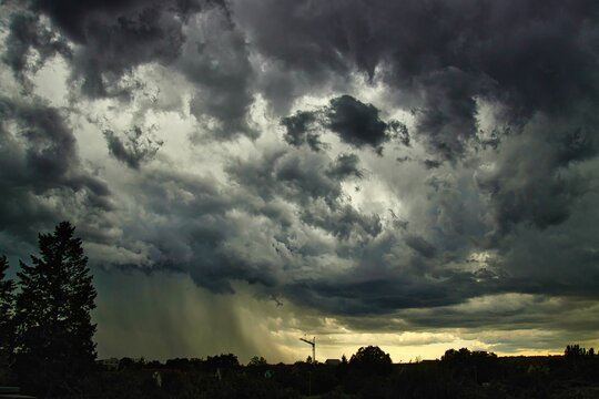 a storm is rolling in over a dark sky with sunbeams on the sky