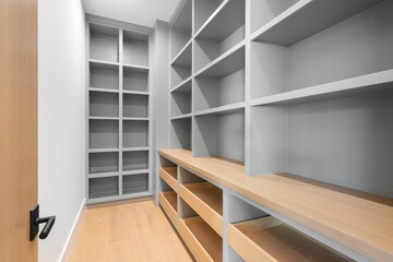 a large closet with white walls and wood shelves and open shelves