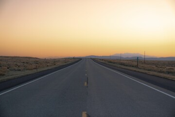 Idyllic country road leading to the summit, illuminated by a warm and stunning sunset