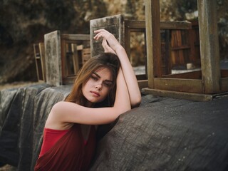 Young woman with a sad look looks into the camera with loose hair portrait on the beach on a trip...