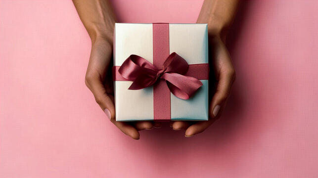 Generative AI illustration of top view of crop anonymous female holding present box in daytime on pink background