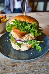 Close-up of a juicy hamburger on a white plate with lettuce, and tomato