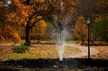 Idyllic autumn scene featuring a water spout surrounded by vibrant autumn trees