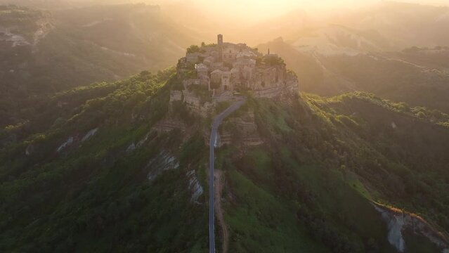 Civita di Bagnoregio, aerial view of an ancient Italian city standing on top of a plateau, illuminated by the sun. Famously known as the dying city. City on rock over Tiber river valley