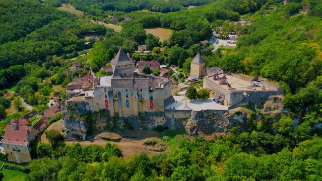 Drone footage over Castelnaud-la-Chapelle Castle with wood trees in France
