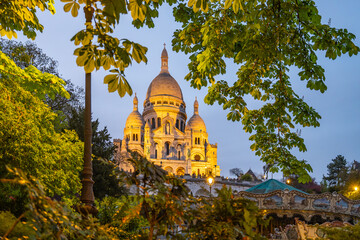 The Basilica of Sacre Coeur de Montmartre illuminated in the evening. Roman Catholic church and...