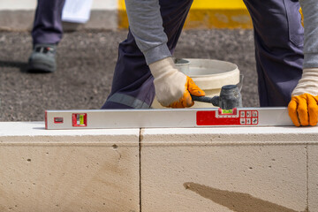 The bricklayer is working. Building a wall of aerated concrete. Gasbeton wall