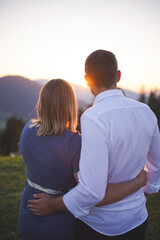 couple holding each other during the sunset in the mountains