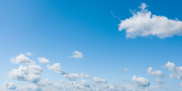 Panoramic photo of a clear blue sky and white clouds over horizon