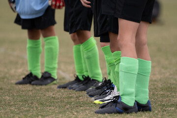 Boys soccer team of young legs wearing socks, shin guards, and cleats