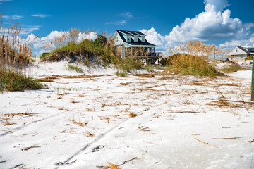 Summer houses on stilts along the shore of the Atlantic Ocean. Blue sky with snow-white clouds.