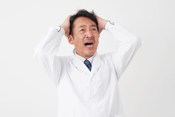 頭を抱える中年の医師　白背景