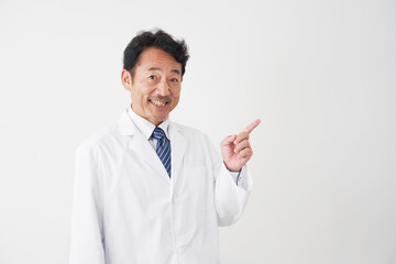 右側を指差す中年の医師　白背景