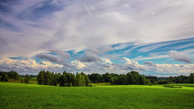 Cumulus and Cirrus Clouds Drift Across the Lush Green Countryside Overhead in a Motion Timelapse in Latvia.
