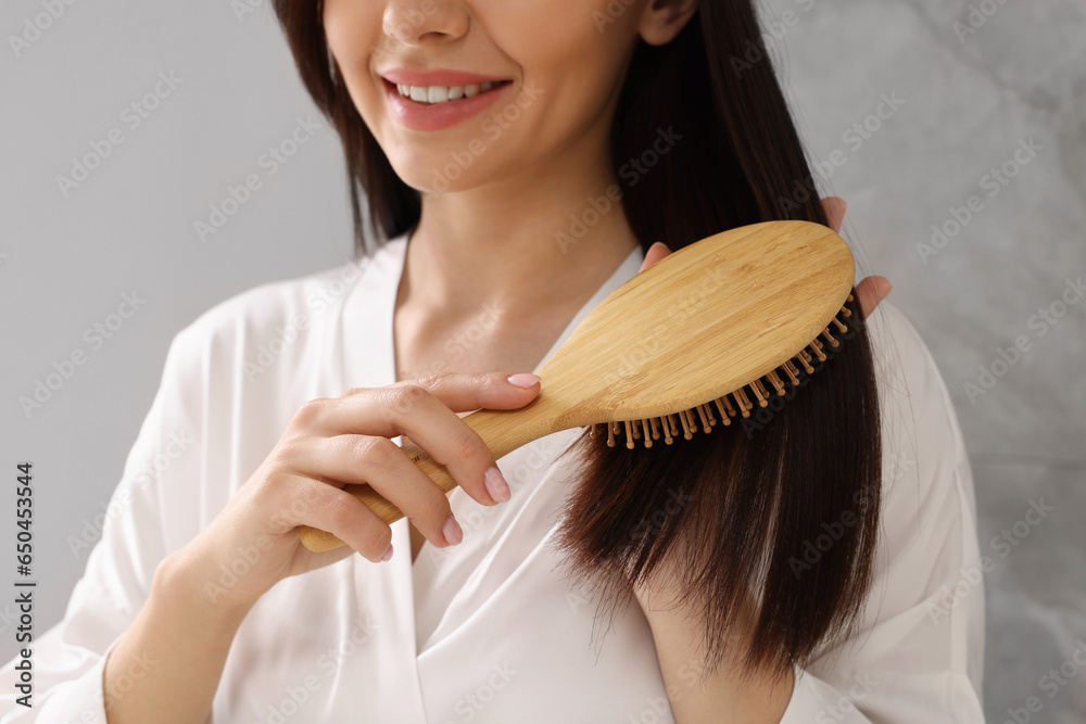 Poster Woman brushing her hair indoors, closeup view