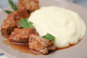 Delicious goulash and mashed potato on plate, closeup