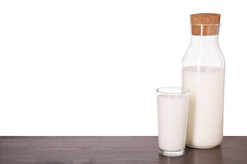 Glassware with tasty milk on wooden table against white background