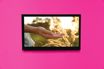 TV screen with movie frame on pink wall