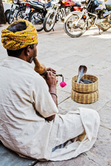 Snake charmer intertaining tourist on the streets of Delhi India