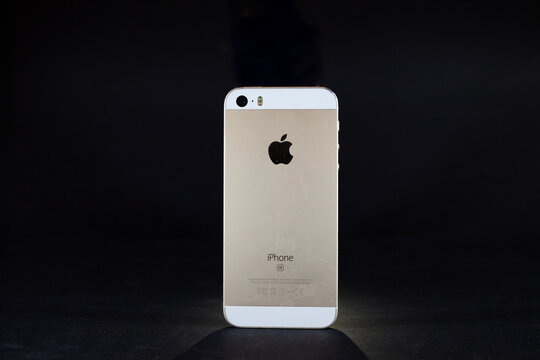 BELGRADE, SERBIA - APRIL 13, 2023: Studio shot of a black Iphone SE 1st generation, old and used, isolated on black background. Released in 2016, IPhone SE 1 is the first generation of Apple.