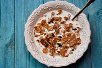 Top view of a bowl of Raisin Bran with milk