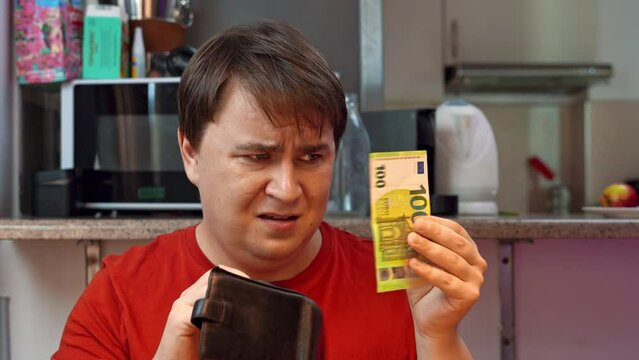 Greedy man pulls out hundred euro bill from wallet, gives it away emotionally, unhappy expression on face Husband divides family budget, gives children pocket money Poor man mindset, money energy
