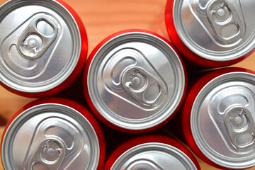 close up group of aluminium red cans soft drink put on brown wooden table