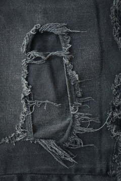 torn black danim texture background, textile of jeans fashion for clothing design