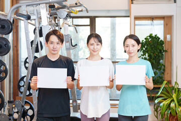 スポーツジムで運動する男性と女性・ホワイトボード