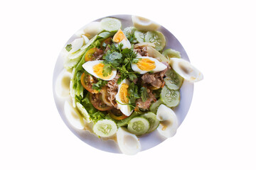 Laos salad placed on a white plate on a wooden table, top view, isolated background
