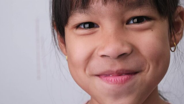 Close-up of cute young girl smiling wide, showing empty space with growing first front teeth. Little girl with big smile and missing milk teeth. Dental hygiene concept