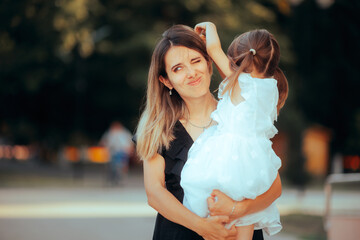 Daughter Bothering her Mom Playing with her Hair. Attention seeking kid pulling her mom hair making...